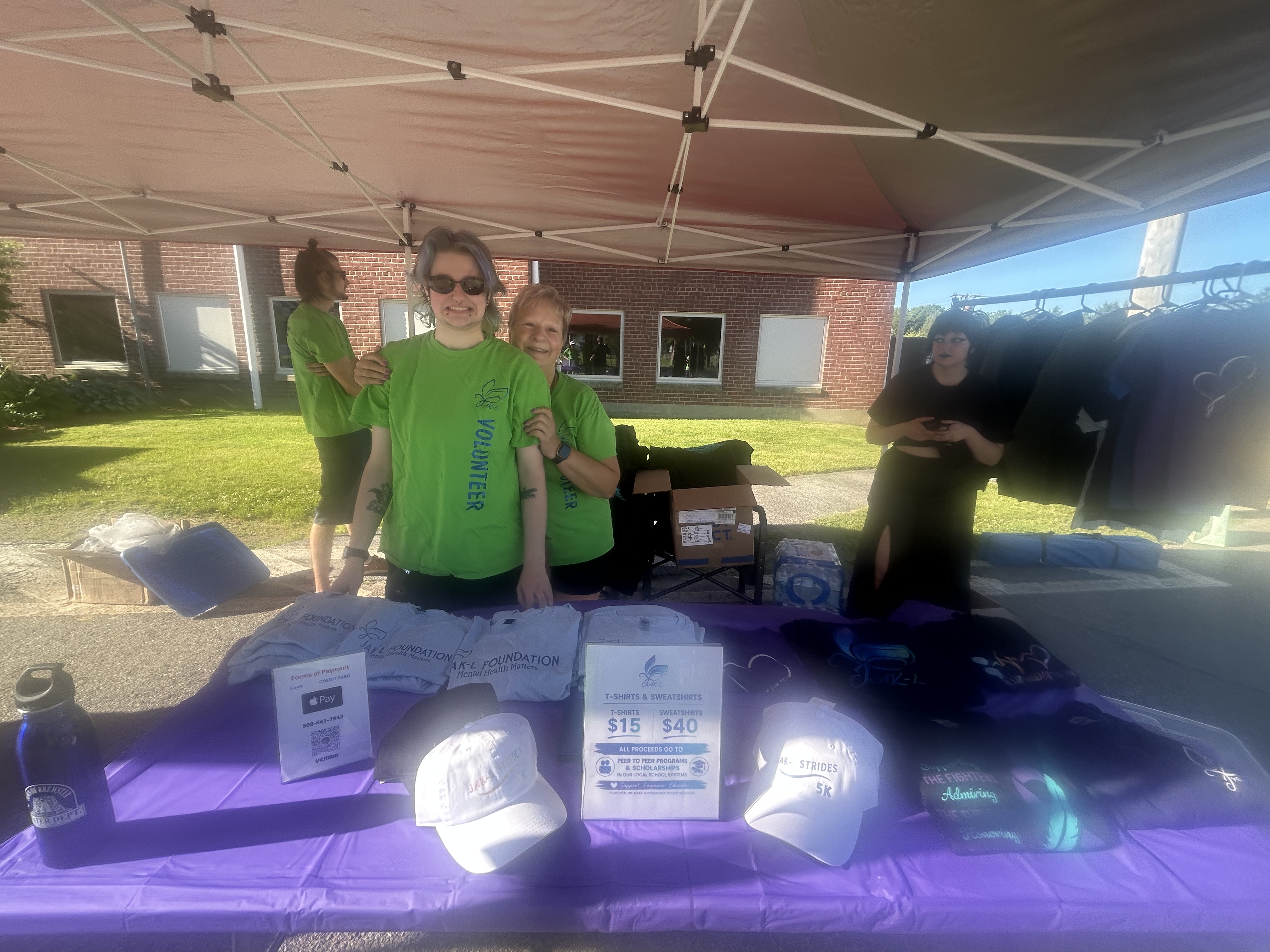 JAK-L Foundation merchandise table with volunteers